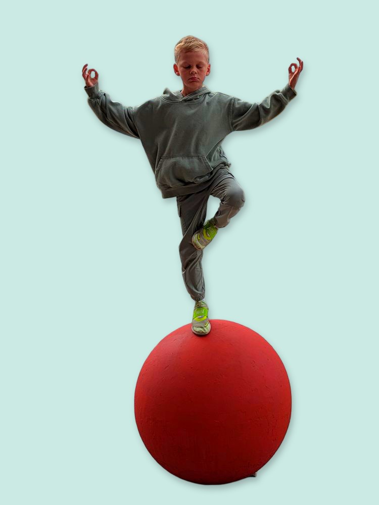 Jude balancing in a yoga pose on a big coral ball